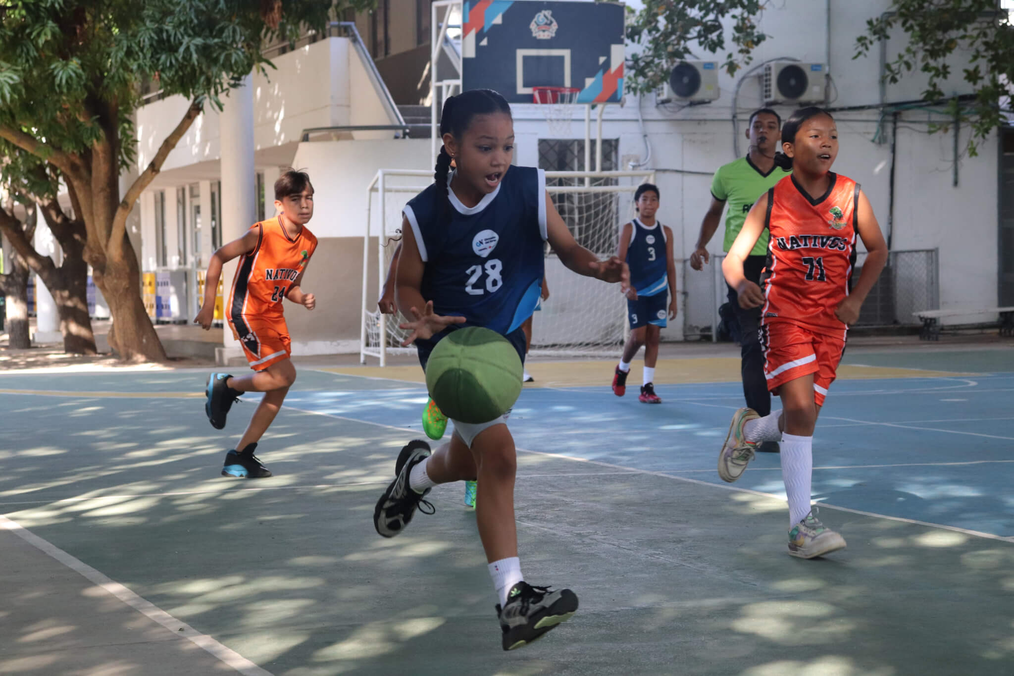 Niña en cancha de de baloncesto en torneo deportivo