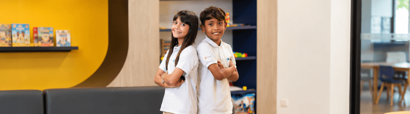 Niños sonriendo a cámara en un aula